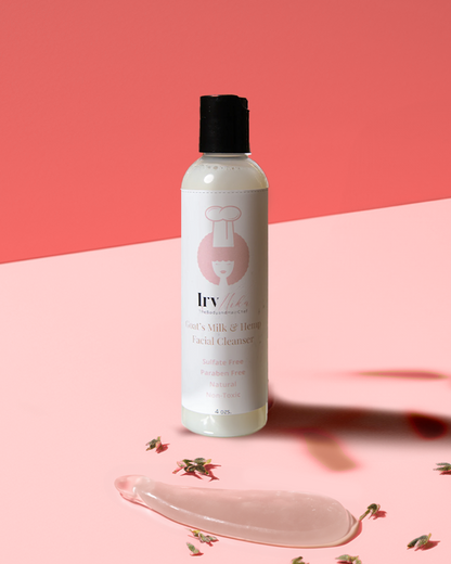 Purifying Goat Milk & Hemp Facial Cleanser bottle on a pink background with a smooth gel and herbs.